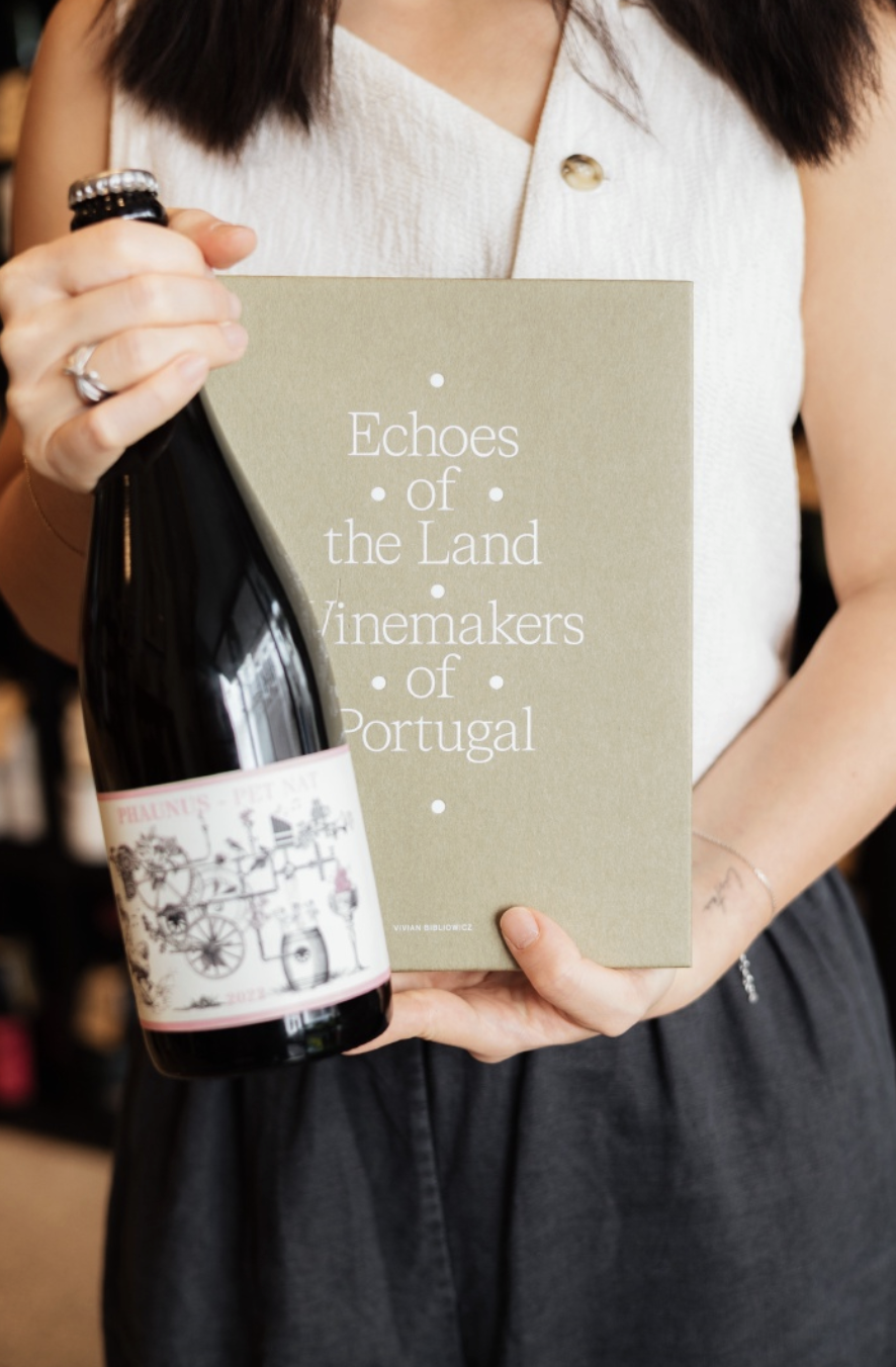 Christine holding wine book and bottle